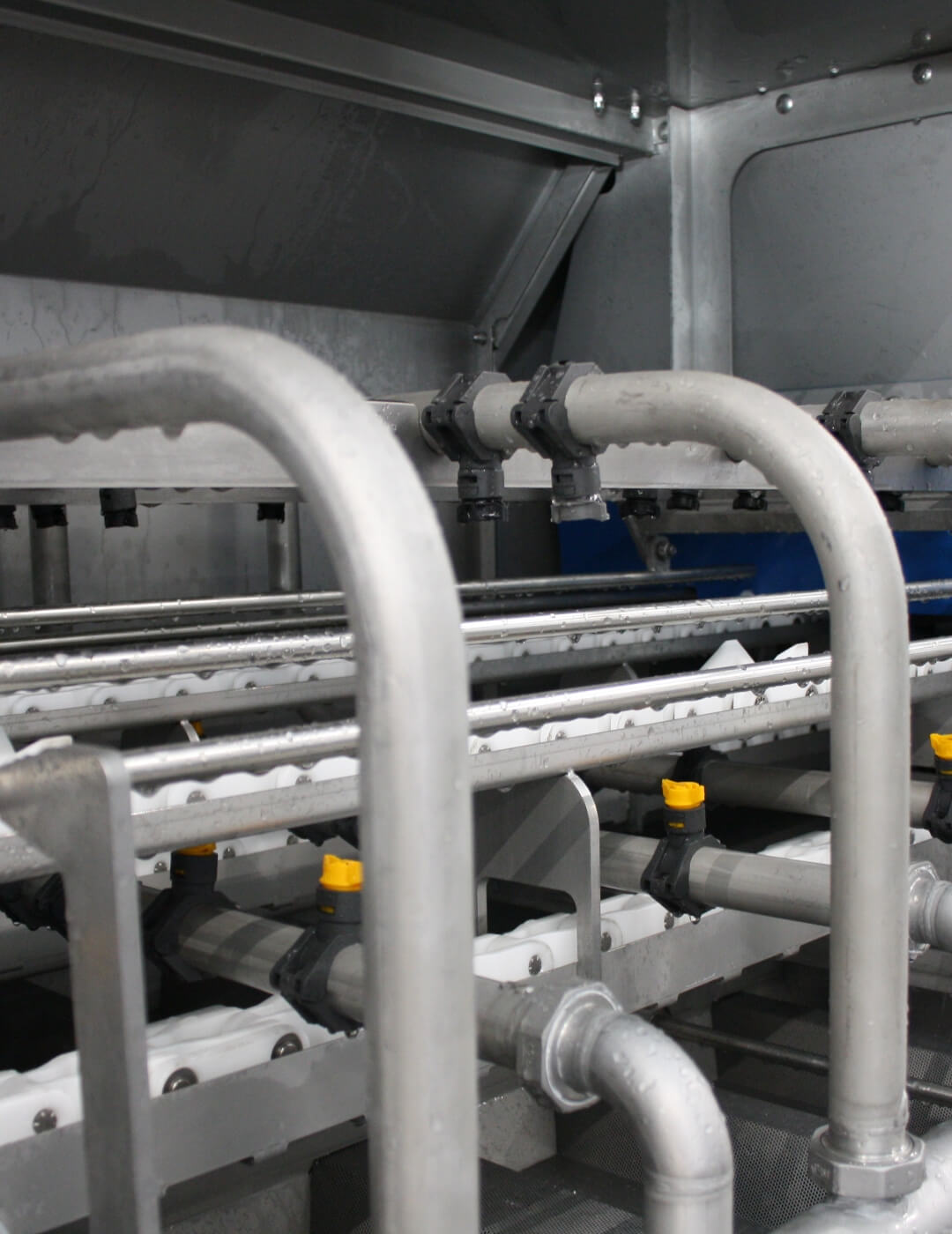 Spraying sections of an industrial washer for reusable product carriers